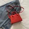 Mini-Handtasche aus rotem Lackleder mit Steppnähten und goldenen Details auf Denim - Rot