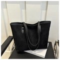 Vista de la textura negra mate del bolso tote con remaches dorados en las correas - Negro
