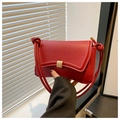 Detail of red leather underarm bag with gold buckle and knotted shoulder strap - Red