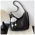 Close-up of black leather hobo tote bag featuring a cute white plush cloud charm - Black with Pendant