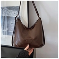 Detail of dark brown faux leather tote showing the logo and dual strap texture - Brown