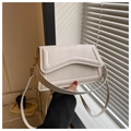 Detail of a cream-white square crossbody bag featuring a unique wavy flap design - White