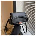 Close-up of black PU leather crossbody bag with wave texture and gold buckle detail - Black