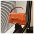 Dettaglio mini borsa in pelle arancione con cuciture ondulate e manico rigido fisso - Arancione