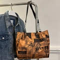 Oranje shopper met krantenprint en zilveren ketting aan een metalen hanger - Oranje