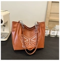 Detail of caramel leather tote bag featuring white butterfly embroidery and chain strap - Yellow Brown
