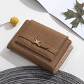 Detailed close-up of brown textured leather wallet with gold metal X-clasp and zip compartment - Brown