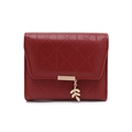 Macro shot of dark red quilted leather wallet featuring a golden leaf pendant and metal trim - Burgundy