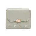 Close-up of light green PU leather wallet with gold floral clasp and floral print detailing - Green