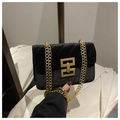 Dettaglio della borsa nera trapuntata con catena, texture glitter e fibbia dorata - Nero