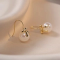Elegant white pearl drop earrings with gold bow clasp on champagne silk fabric background - White Bow Style (E548)