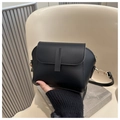 Detail view of a black minimalist half-moon crossbody bag with matte faux leather texture - Black