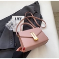 Petit sac à main rose en cuir PU avec boucles dorées sur une veste de costume - Rose