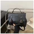Detail of black vintage leather backpack with embossed text and gold metal hardware - Black
