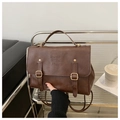 Detailed close-up of dark brown PU leather backpack with vintage metal buckles and handle - Brown
