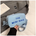 Light blue mini camera bag with THE MINI BAG text and geometric woven strap detail - Blue