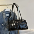 Glossy black underarm bag with double pockets and silver bow charm on a metal stand - Black