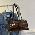 Deep brown faux leather trendy shoulder bag featuring front pockets and silver bow charm - Brown