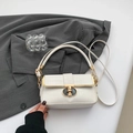 Elegante bolso blanco de piel de cocodrilo con detalles dorados sobre blazer gris - Blanco