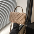 Detailed view of beige crossbody bag with V-shaped quilting and gold hardware accents - Khaki