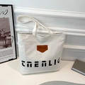 Borsa tote in tela bianca con tipografia nera ed etichetta in pelle marrone elegante - Bianco