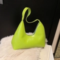 Bolso de hombro verde neón brillante en cuero de patente sobre fondo de felpa blanca suave - Verde