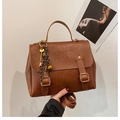 Detail of brown PU leather tote bag with COIN 7NP embossing and decorative pendant - With Charm / Brown