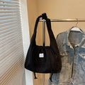 Retro black corduroy drawstring shoulder bag with brand label in a lifestyle setting - Black