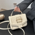 Borsa a tracolla minimalista in pelle beige con fibbia dorata in scatto lifestyle - Bianco