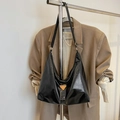 Shiny black faux leather hobo bag with orange logo detail on a beige blazer setup - Black (Without Charm)