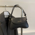 Detalle de bolso negro mate con letras doradas y diseño de correa con nudos - Negro