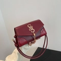 Burgundy flap shoulder bag with crocodile texture, gold logo, and tassel pendant detail - Red