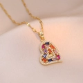 Elegante collar con colgante de corazón dorado y gemas de colores sobre fondo de seda - Corazón de Colores (X0905)