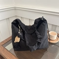 Detalle de bolso tote negro con cordón, textura plisada y un colgante de oveja de peluche - Negro (Con Colgante)