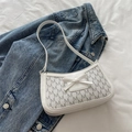 Detalle de bolso baguette blanco con estampado M y lazo sobre una chaqueta vaquera - Blanco