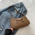 Detalle de bolso baguette marrón con estampado M, lazo de cuero y fondo de mezclilla - Marrón