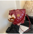 Detail der roten gesteppten Beuteltasche mit Drehverschluss und braunem Plüschanhänger - Rot mit Anhänger