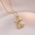 Elegant gold hollow bear pendant necklace with sparkling zircon inlay on pink satin fabric - Gold Hollow Bear Style (X1427)
