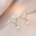 Eleganti orecchini a cuore con diamanti pavé e perle bianche su uno sfondo di raso dorato - Cuore Oro Perla d'Acqua Dolce