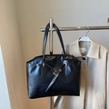 Bolso tote negro grande con acabado brillante y detalles dorados en soporte metálico - Negro