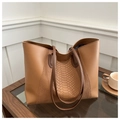Dettaglio di una borsa tote marrone con texture a serpente su un tavolo di legno - Marrone