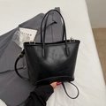 Bolso tipo cubo negro en cuero con textura de lichi y elegantes detalles dorados - Negro
