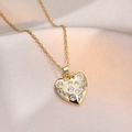 Elegant gold-plated heart pendant necklace with cubic zirconia on champagne silk backdrop - Heart Necklace (X2708) / Gold