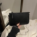 Detailed view of black woven chain bag with silver zipper and rectangular shape - Black