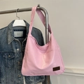 Pink vintage PU leather tote bag with external pocket and logo displayed on metal rack - Pink