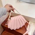 Pink shell-shaped crossbody bag with pearl handle and textured faux leather finish - Pink