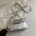 Silver metallic saddle bag with a decorative bow and adjustable strap on a white fabric - Silver