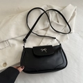 Minimalist black faux leather crossbody bag with a silver metal bow buckle accent - Black