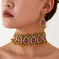 Macro detail of bohemian choker and earrings set with red teardrop stones and gold filigree - Rose Red