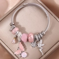 Silver twisted cable bangle with pink butterfly, engraved heart, and fairy charms - Pink